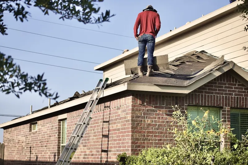 Professional roofer working on a residential roof in Stiles Crossing